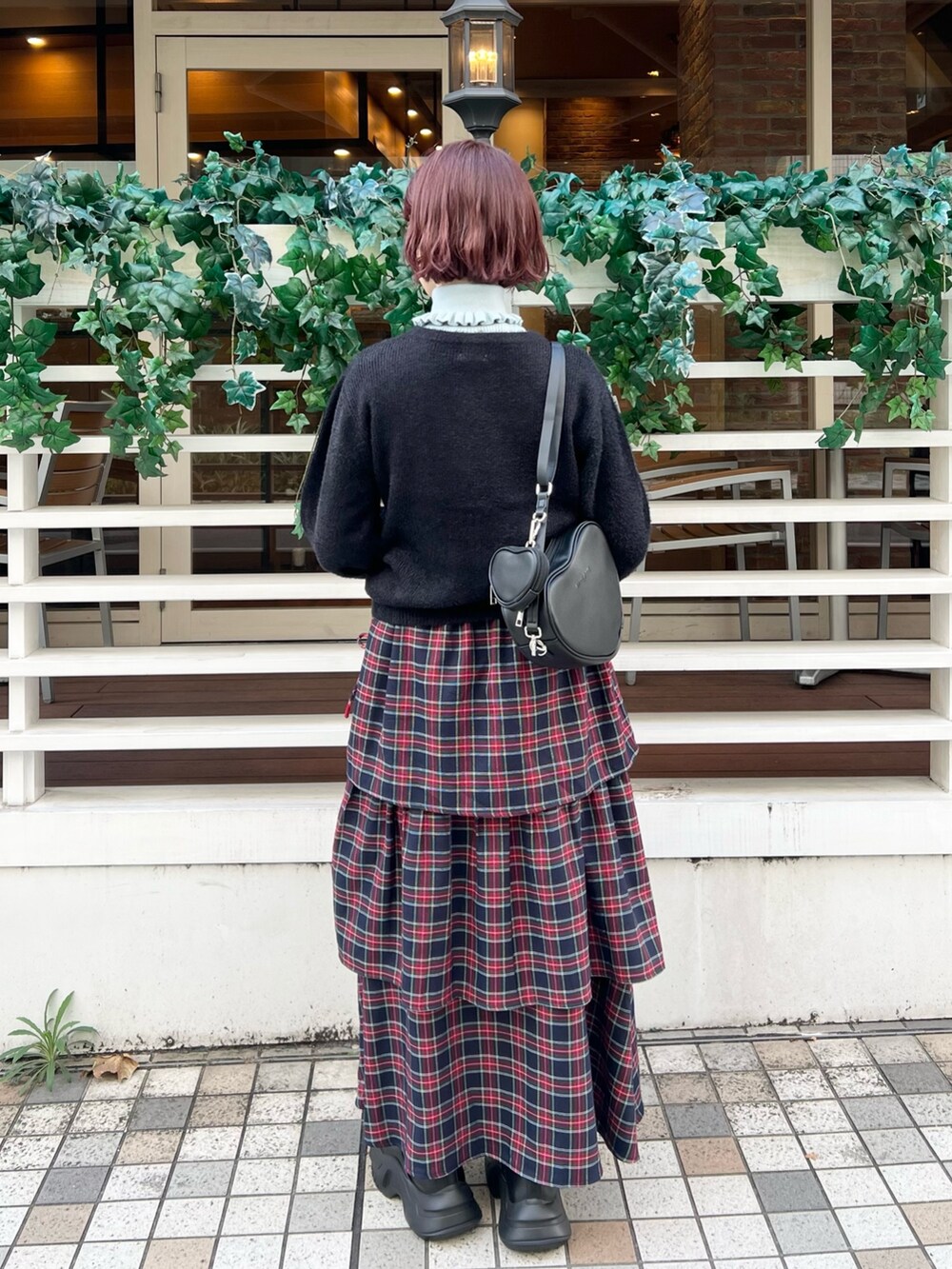 ブルー系のニット/セーター、ブルー系のスカート、ブラック系のスニーカーを着用したレディースの秋コーディネートの3枚目の写真