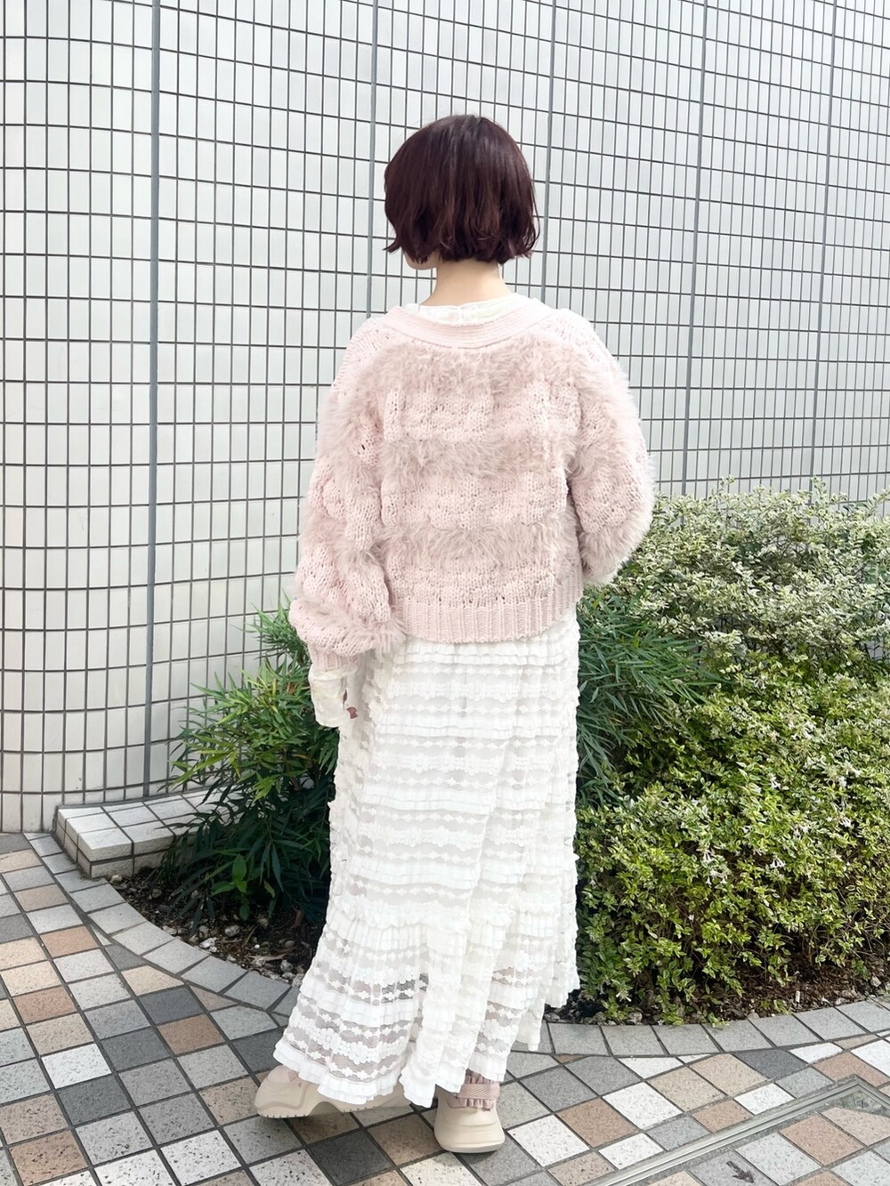 ホワイト系のスカート、ホワイト系のTシャツ/カットソー、ピンク系のスニーカーを着用したレディースの秋コーディネートの3枚目の写真