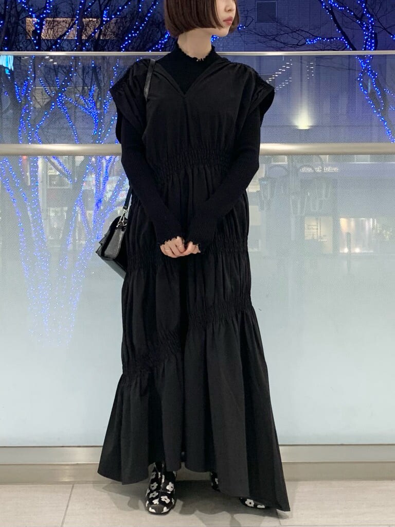 ブラック系のブーツ、ブラック系のニット/セーター、ブラック系のワンピースを着用したレディースの冬コーディネートの3枚目の写真