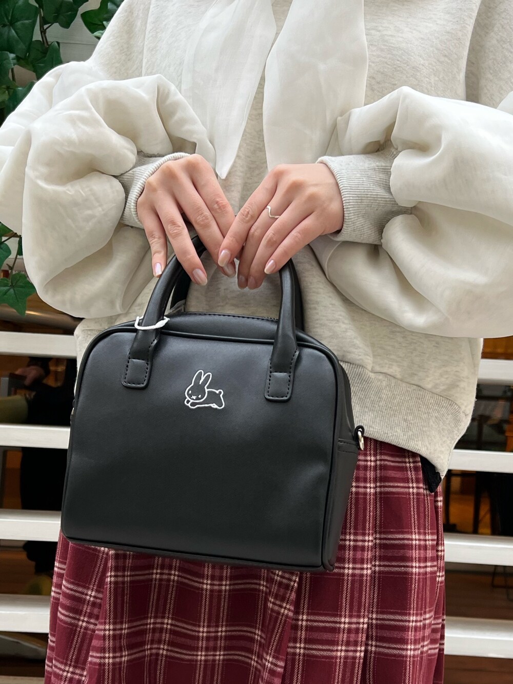 ブラック系のローファー、ホワイト系のパーカー、ブラック系のボストンバッグを着用したレディースの冬コーディネートの8枚目の写真