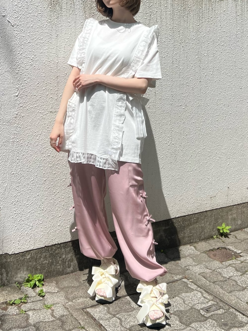 ピンク系のカーゴパンツ、ホワイト系のTシャツ/カットソー、ホワイト系のサンダルを着用したレディースの春コーディネートの2枚目の写真