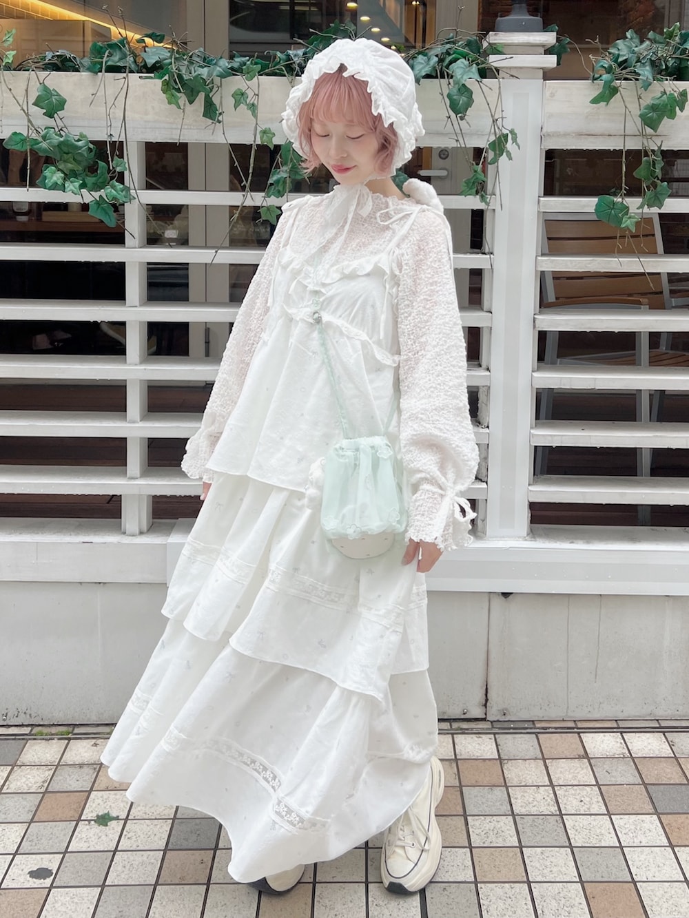 ホワイト系のTシャツ/カットソー、グリーン系のハンドバッグ、ホワイト系のワンピースを着用したレディースの冬コーディネートの5枚目の写真