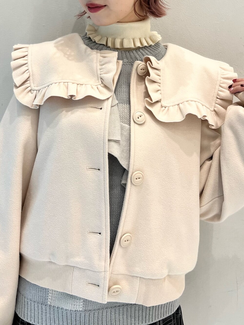 ブラック系のスカート、ブルー系のニット/セーター、ホワイト系のブーツを着用したレディースの冬コーディネートの5枚目の写真