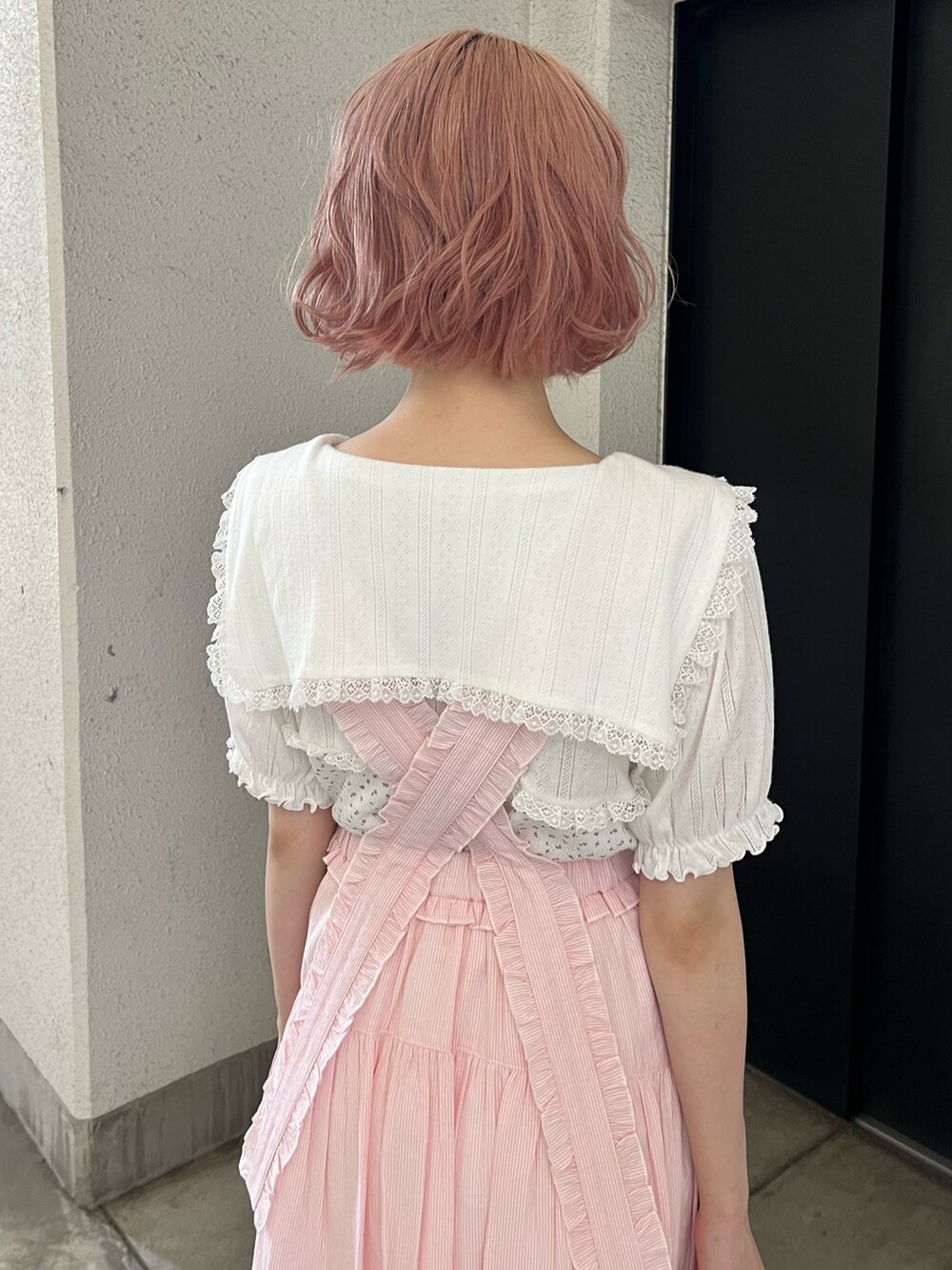 ホワイト系のTシャツ/カットソー、ピンク系のジャンパースカート、ホワイト系のサンダルを着用したレディースの夏コーディネートの9枚目の写真