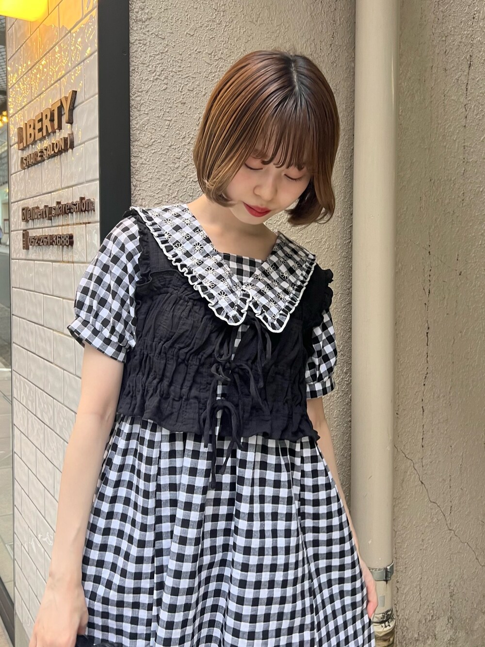 ブラック系のベスト、ブラック系のサンダル、ブラック系のワンピースを着用したレディースの夏コーディネートの6枚目の写真