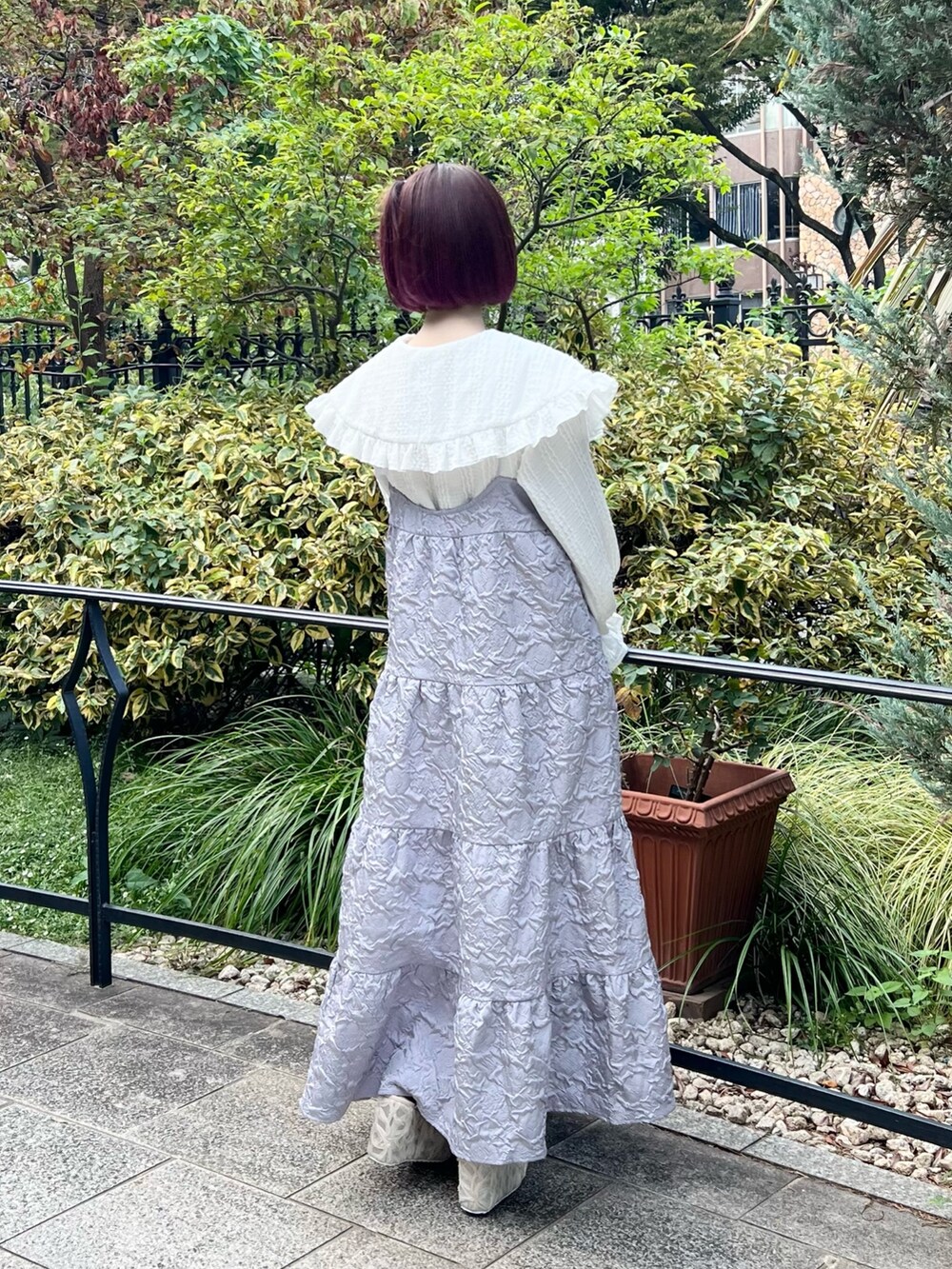 ホワイト系のシャツ/ブラウス、パープル系のワンピース、ホワイト系のサンダルを着用したレディースの秋コーディネートの6枚目の写真