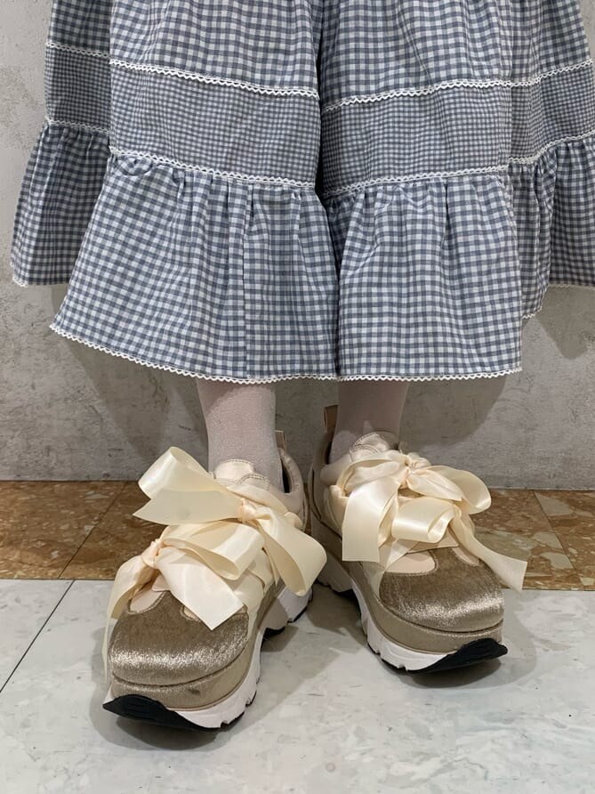 ホワイト系のシャツ/ブラウス、ブルー系のスカート、ホワイト系のスニーカーを着用したレディースの冬コーディネートの4枚目の写真