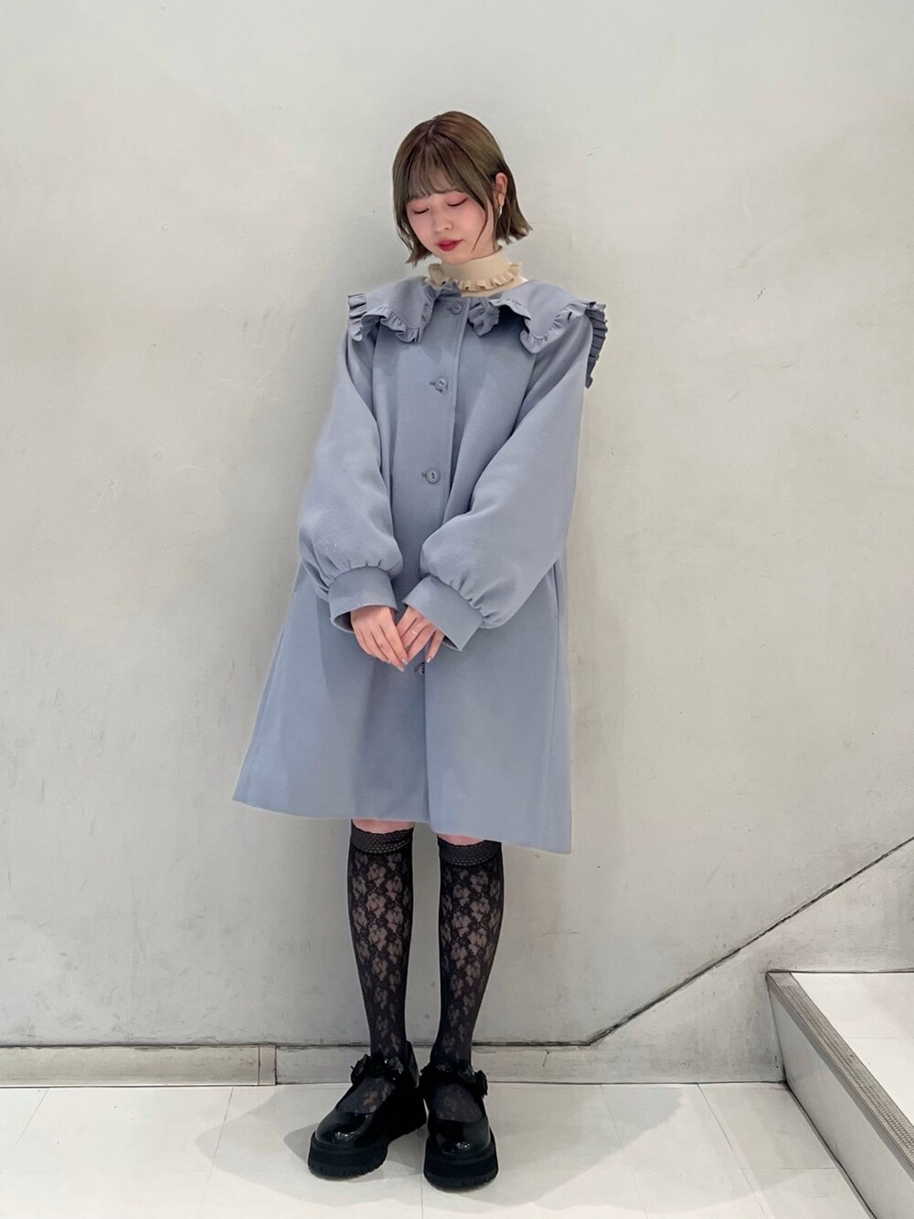 ブラック系のローファー、ブルー系のその他アウター、ホワイト系のニット/セーターを着用したレディースの冬コーディネートの2枚目の写真