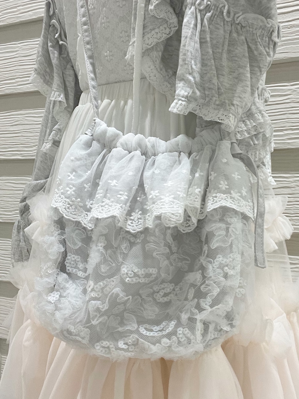 グレー系のカーディガン/ボレロ、ホワイト系のTシャツ/カットソー、ホワイト系のスニーカーを着用したレディースの夏コーディネートの8枚目の写真