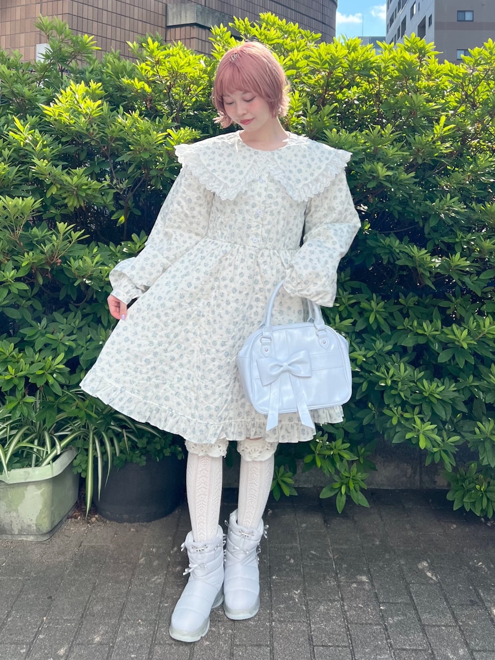 ホワイト系のワンピース、ブルー系のハンドバッグ、ブルー系のブーツを着用したレディースの夏コーディネートの5枚目の写真