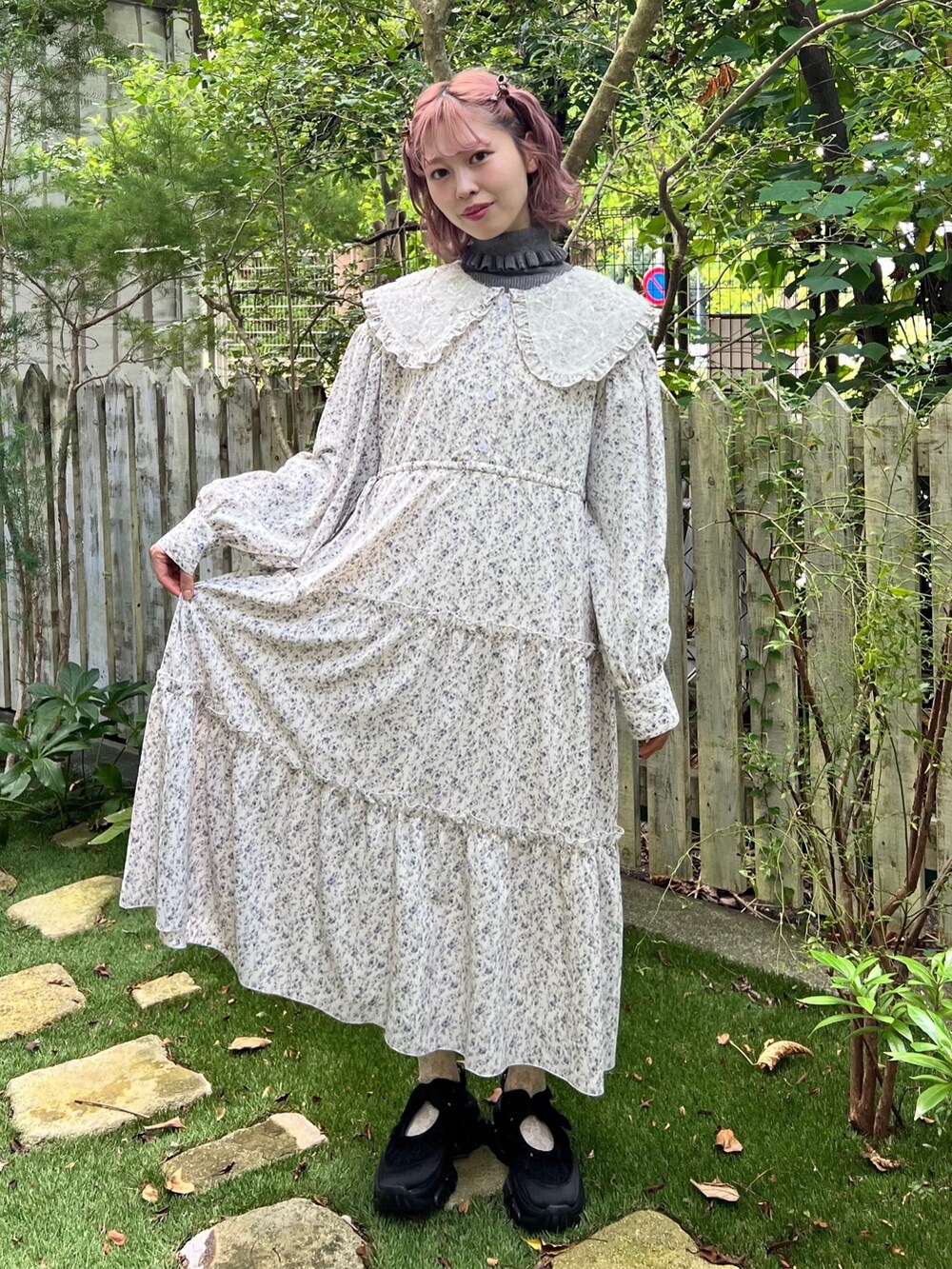 ホワイト系のワンピース、グレー系のニット/セーター、ブラック系のスニーカーを着用したレディースの秋コーディネートの2枚目の写真