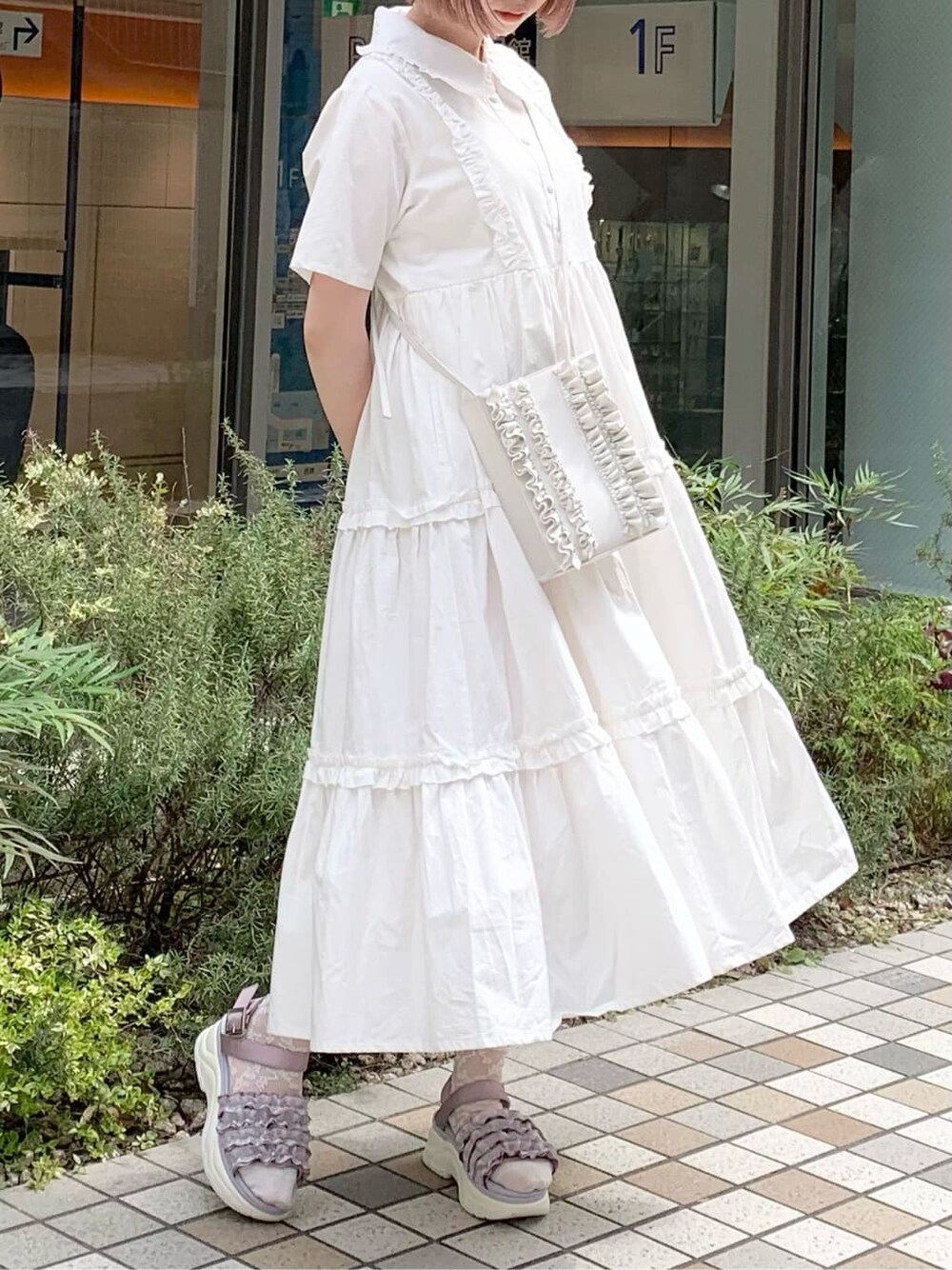 ホワイト系のワンピース、ピンク系のサンダル、ホワイト系のショルダーバッグを着用したレディースの春コーディネートの3枚目の写真