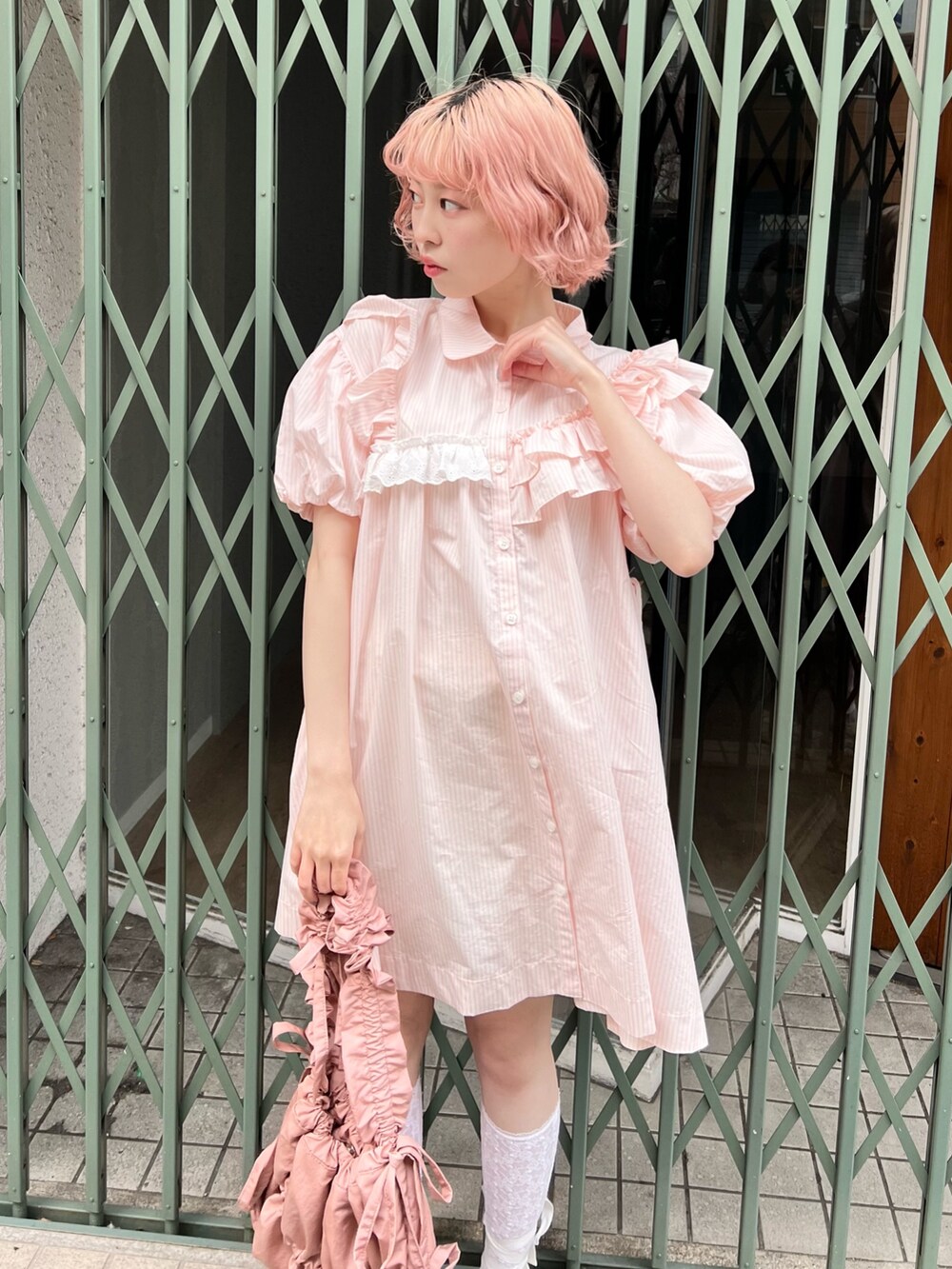 ピンク系のワンピース、ピンク系のトートバッグ、ホワイト系のスニーカーを着用したレディースの春コーディネートの8枚目の写真