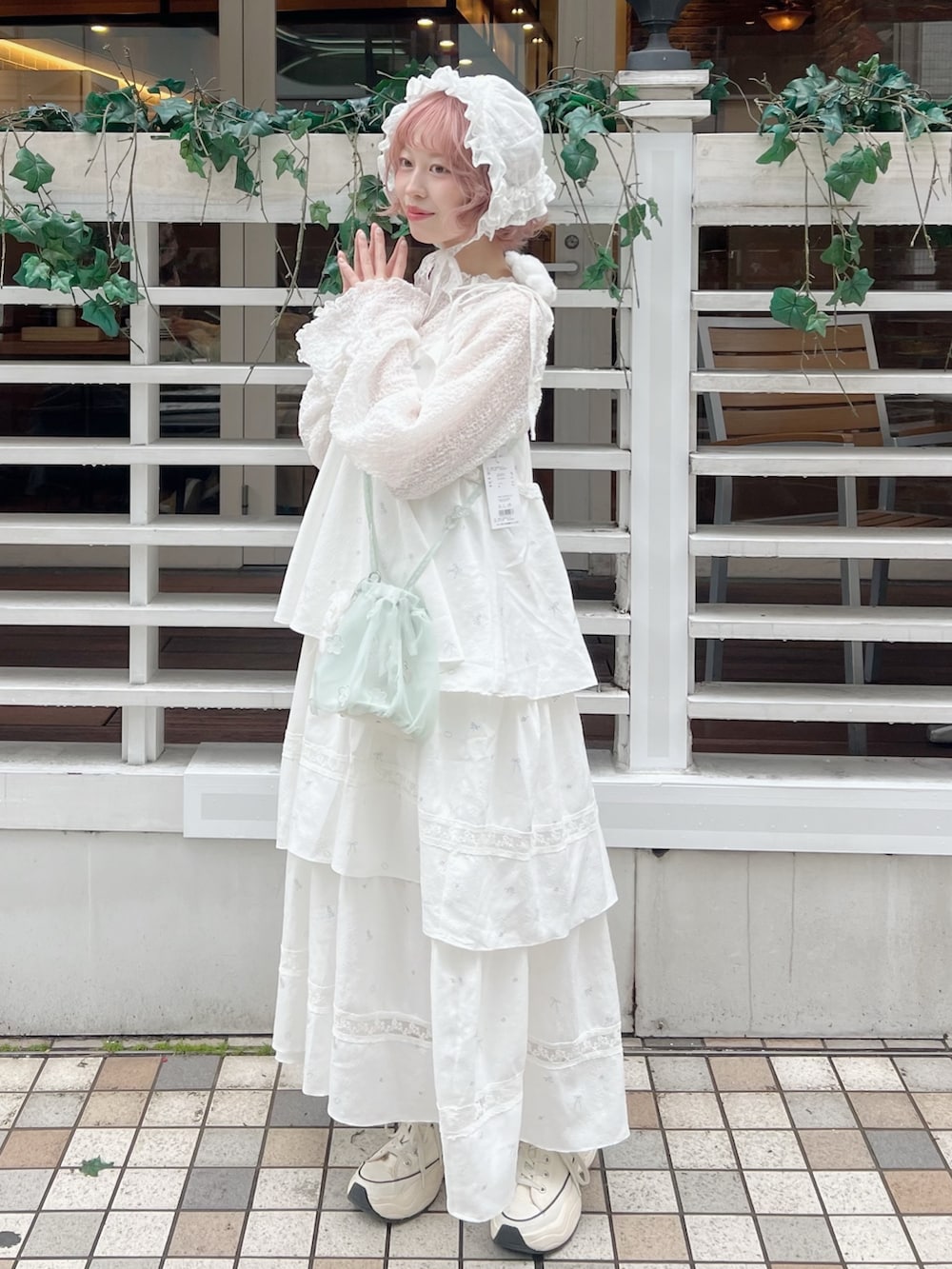 ホワイト系のTシャツ/カットソー、グリーン系のハンドバッグ、ホワイト系のワンピースを着用したレディースの冬コーディネートの2枚目の写真