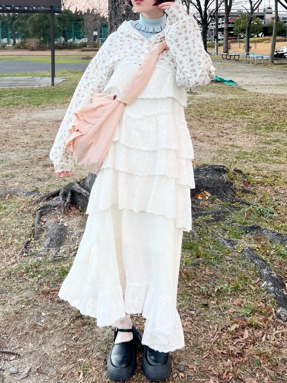 ホワイト系のワンピース、その他のカーディガン/ボレロ、ピンク系のショルダーバッグを着用したレディースの冬コーディネートの2枚目の写真