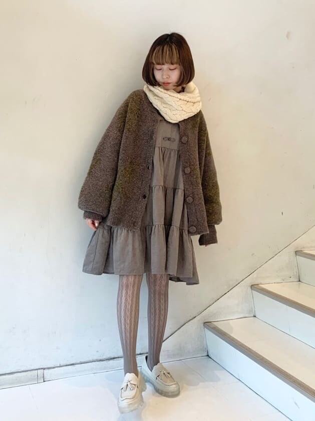 ホワイト系のローファー、ベージュ系のワンピース、パープル系のカーディガン/ボレロを着用したレディースの冬コーディネートの3枚目の写真