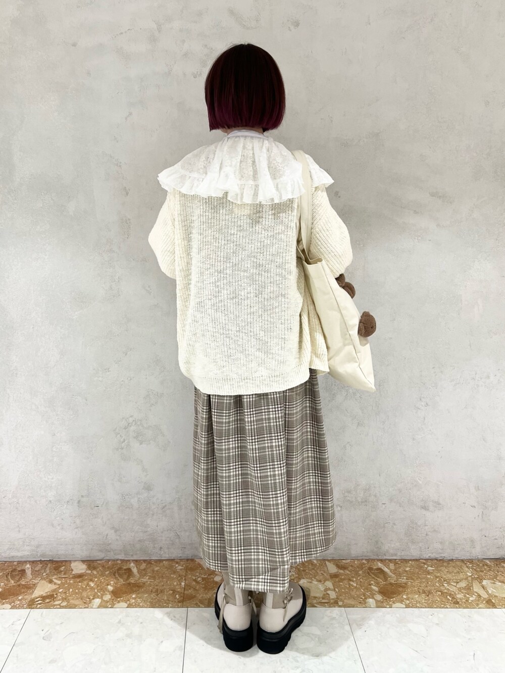 ベージュ系のワンピース、ホワイト系のシャツ/ブラウス、ホワイト系のカーディガン/ボレロを着用したレディースの秋コーディネートの3枚目の写真