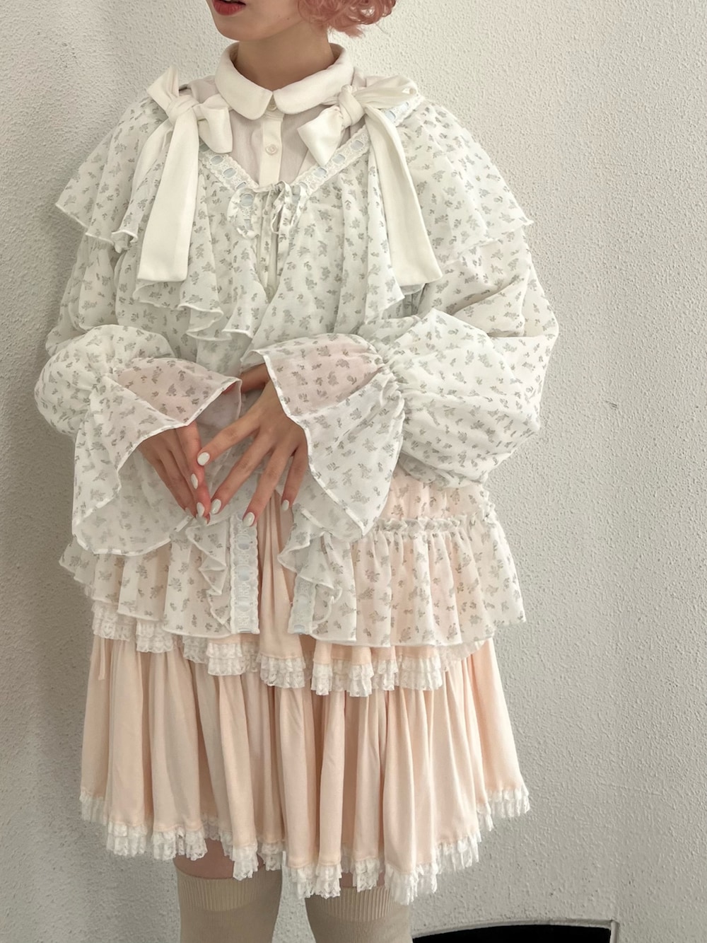 ブルー系のカーディガン/ボレロ、ピンク系のスカート、ホワイト系のスニーカーを着用したレディースの冬コーディネートの7枚目の写真