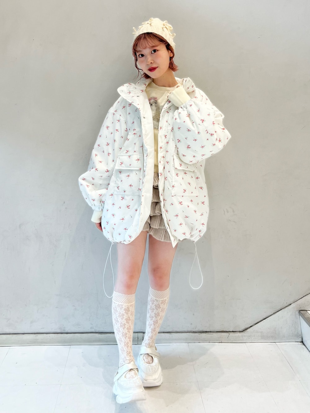 ピンク系のブルゾン、ベージュ系のスウェットパンツ、ホワイト系のニット/セーターを着用したレディースの冬コーディネートの8枚目の写真