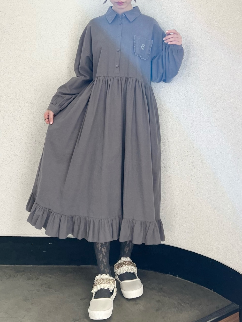 ブラック系のブルゾン、グレー系のワンピース、ホワイト系のスニーカーを着用したレディースの冬コーディネートの5枚目の写真