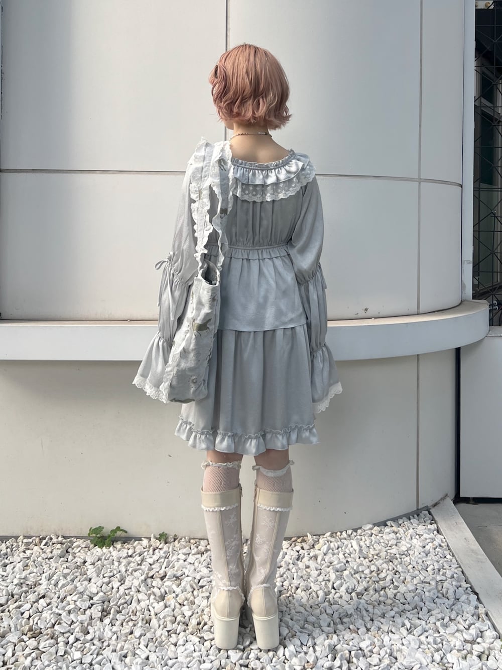 ブルー系のワンピース、ブルー系のトートバッグ、ホワイト系のブーツを着用したレディースの夏コーディネートの4枚目の写真