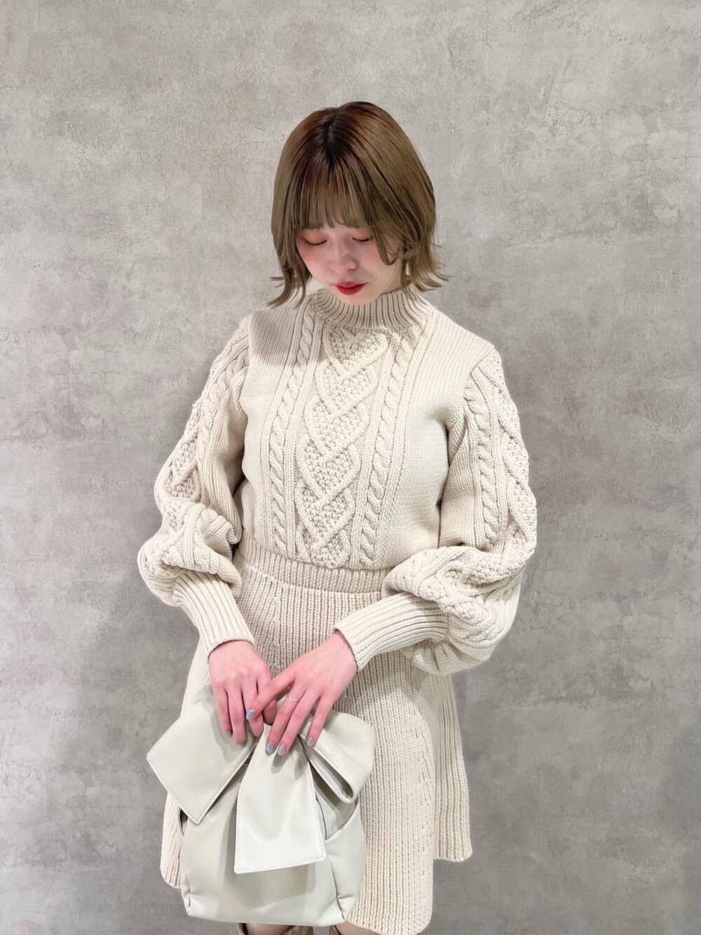 ホワイト系のワンピース、ベージュ系のブーツ、ホワイト系のショルダーバッグを着用したレディースの冬コーディネートの4枚目の写真