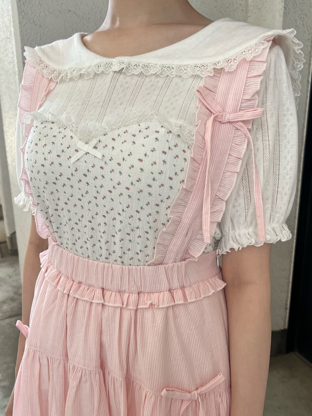 ホワイト系のTシャツ/カットソー、ピンク系のジャンパースカート、ホワイト系のサンダルを着用したレディースの夏コーディネートの10枚目の写真