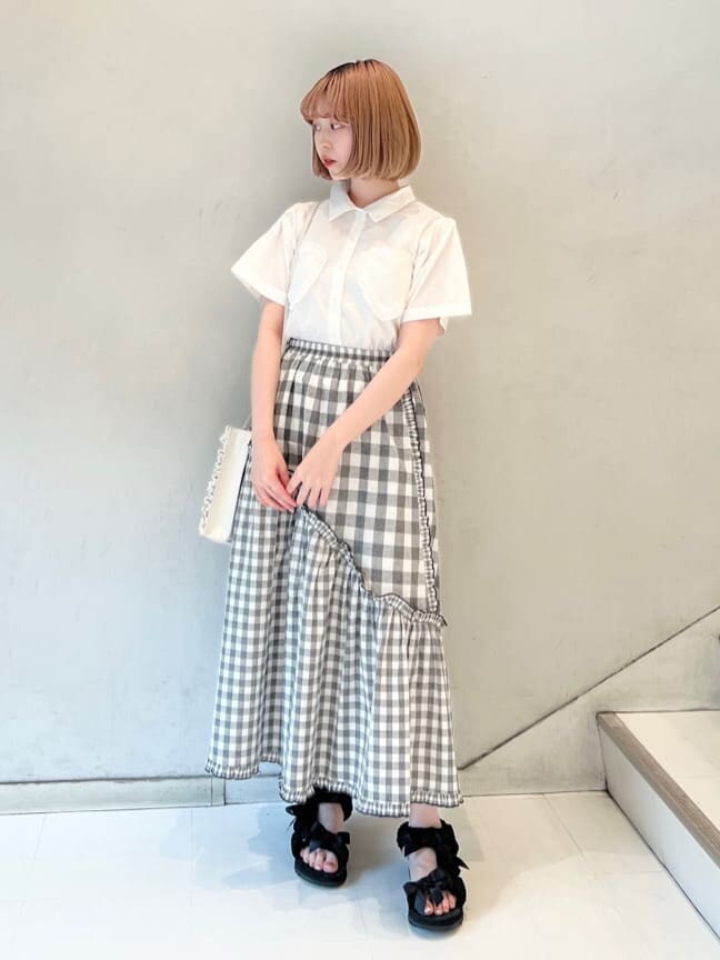 ホワイト系のショルダーバッグ、ブラック系のスカート、ブラック系のサンダルを着用したレディースの夏コーディネートの2枚目の写真