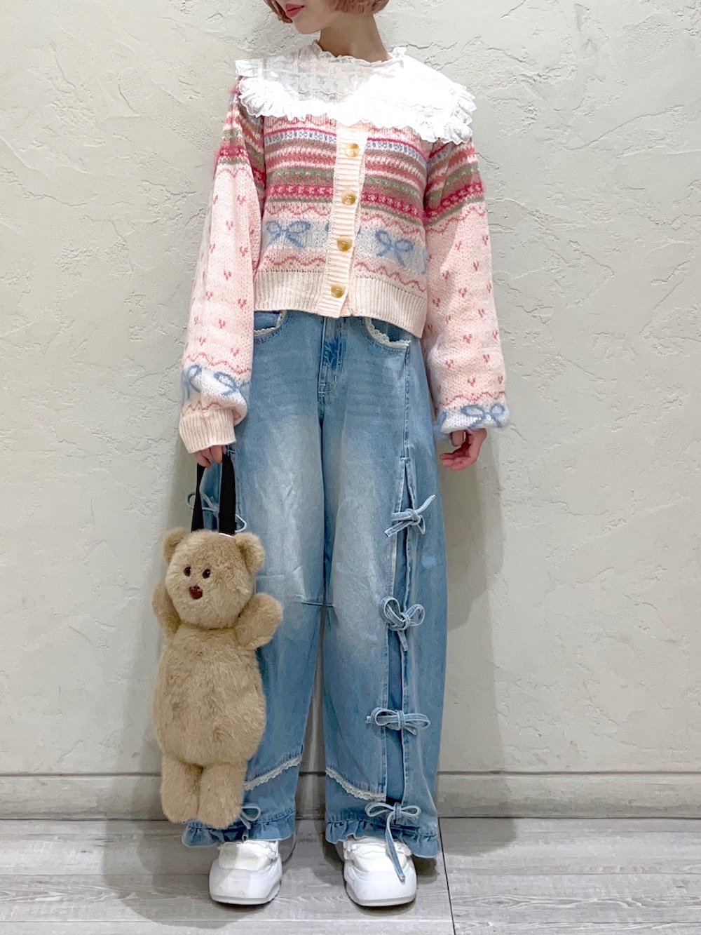 ピンク系のカーディガン/ボレロ、ホワイト系のシャツ/ブラウス、ベージュ系のハンドバッグを着用したレディースの秋コーディネートの2枚目の写真