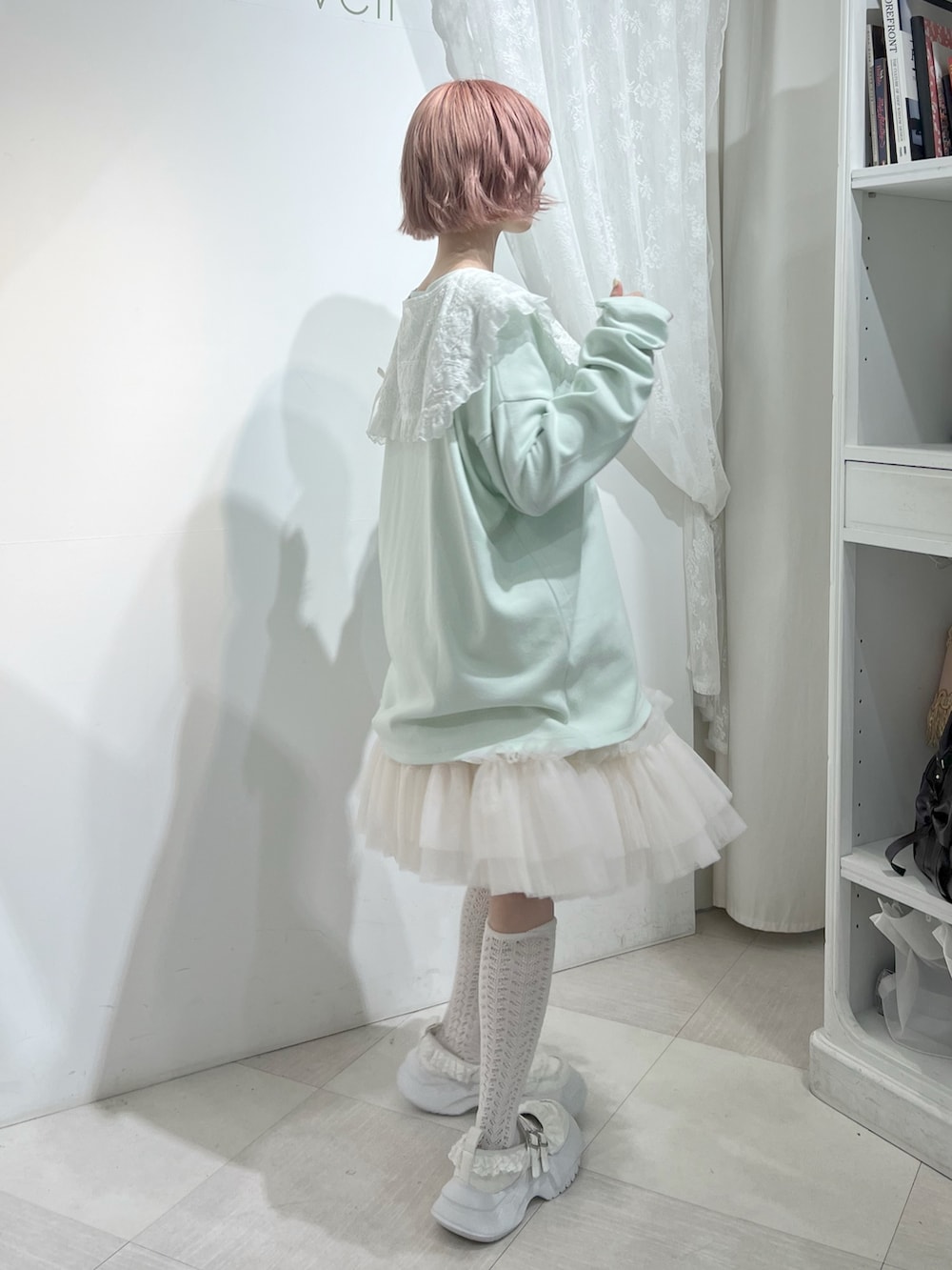 グリーン系のTシャツ/カットソー、ピンク系のスカート、ホワイト系のスニーカーを着用したレディースの夏コーディネートの3枚目の写真