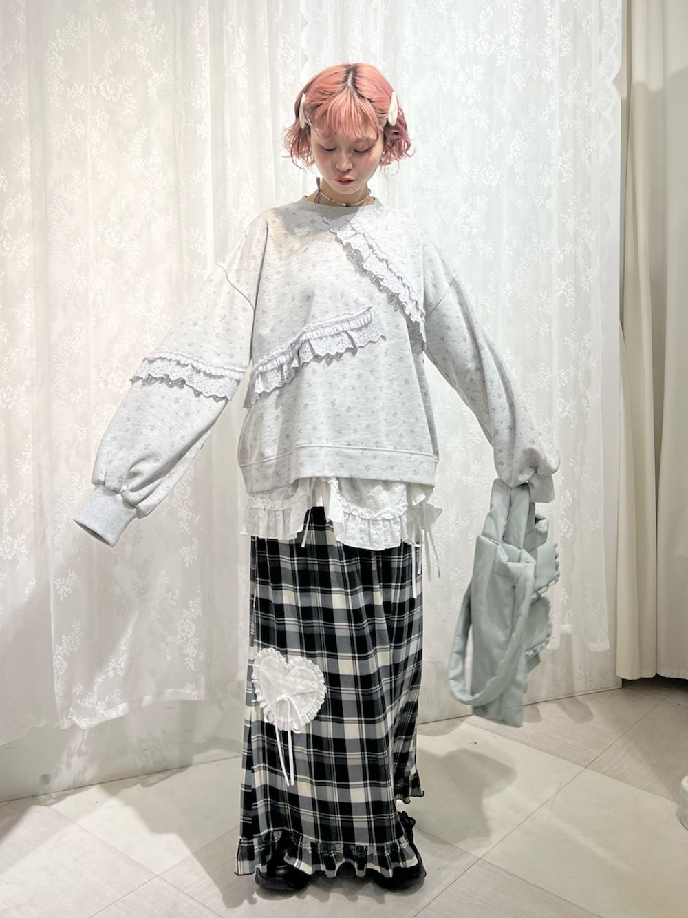 グレー系のスウェット、ベージュ系のスカート、ブラック系のスニーカーを着用したレディースの冬コーディネートの2枚目の写真