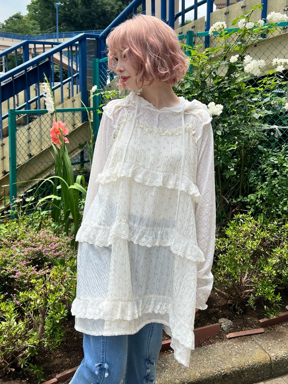 ホワイト系のチュニック、ホワイト系のTシャツ/カットソー、ブルー系のデニムパンツを着用したレディースの夏コーディネートの8枚目の写真