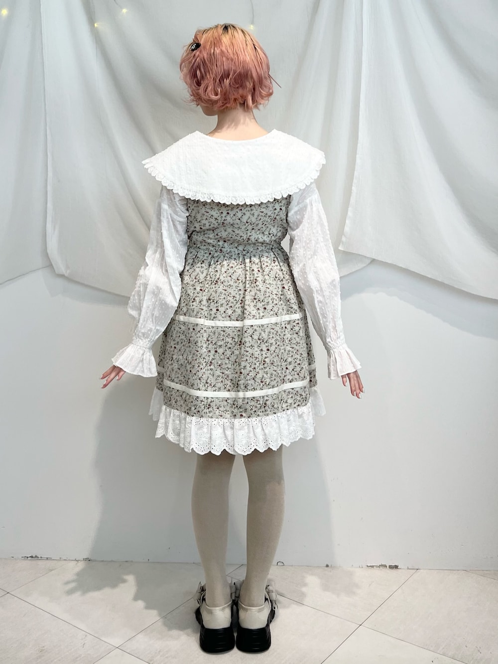 ホワイト系のシャツ/ブラウス、グリーン系のワンピース、ホワイト系のスニーカーを着用したレディースの冬コーディネートの4枚目の写真