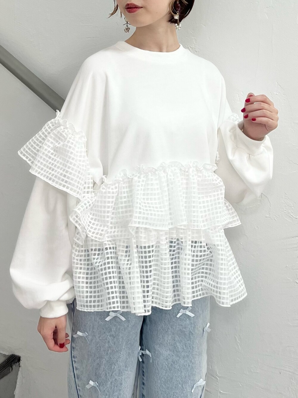 ホワイト系のスウェット、ブルー系のデニムパンツ、ホワイト系のスニーカーを着用したレディースの春コーディネートの8枚目の写真