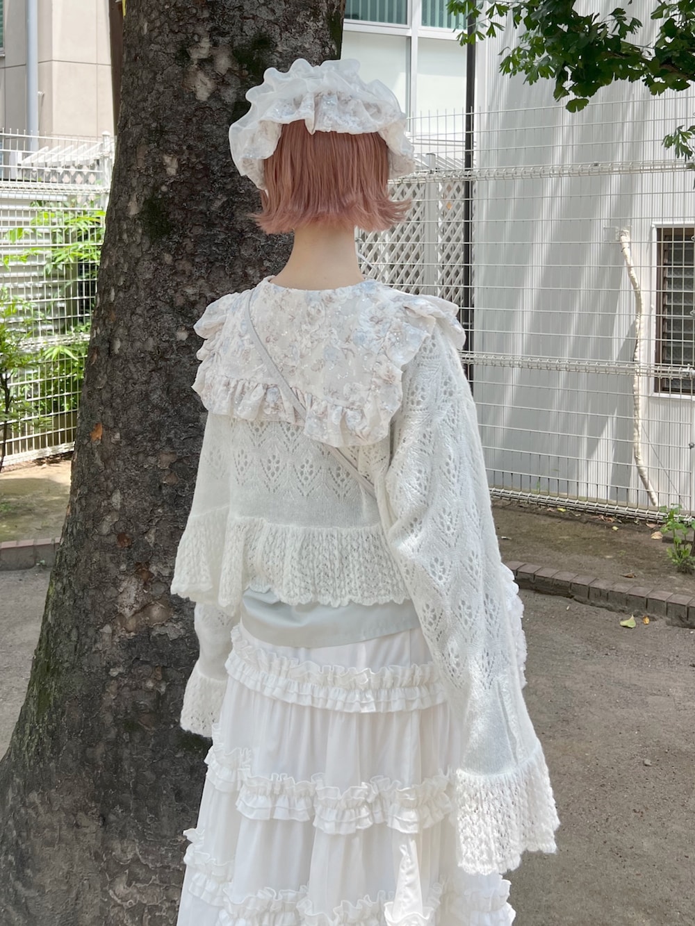 ホワイト系のハンドバッグ、ホワイト系のスカート、ホワイト系のブーツを着用したレディースの夏コーディネートの7枚目の写真