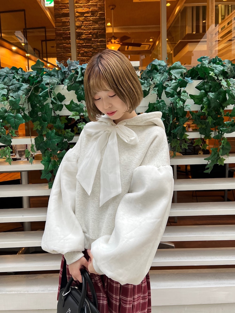 ブラック系のローファー、ホワイト系のパーカー、ブラック系のボストンバッグを着用したレディースの冬コーディネートの5枚目の写真