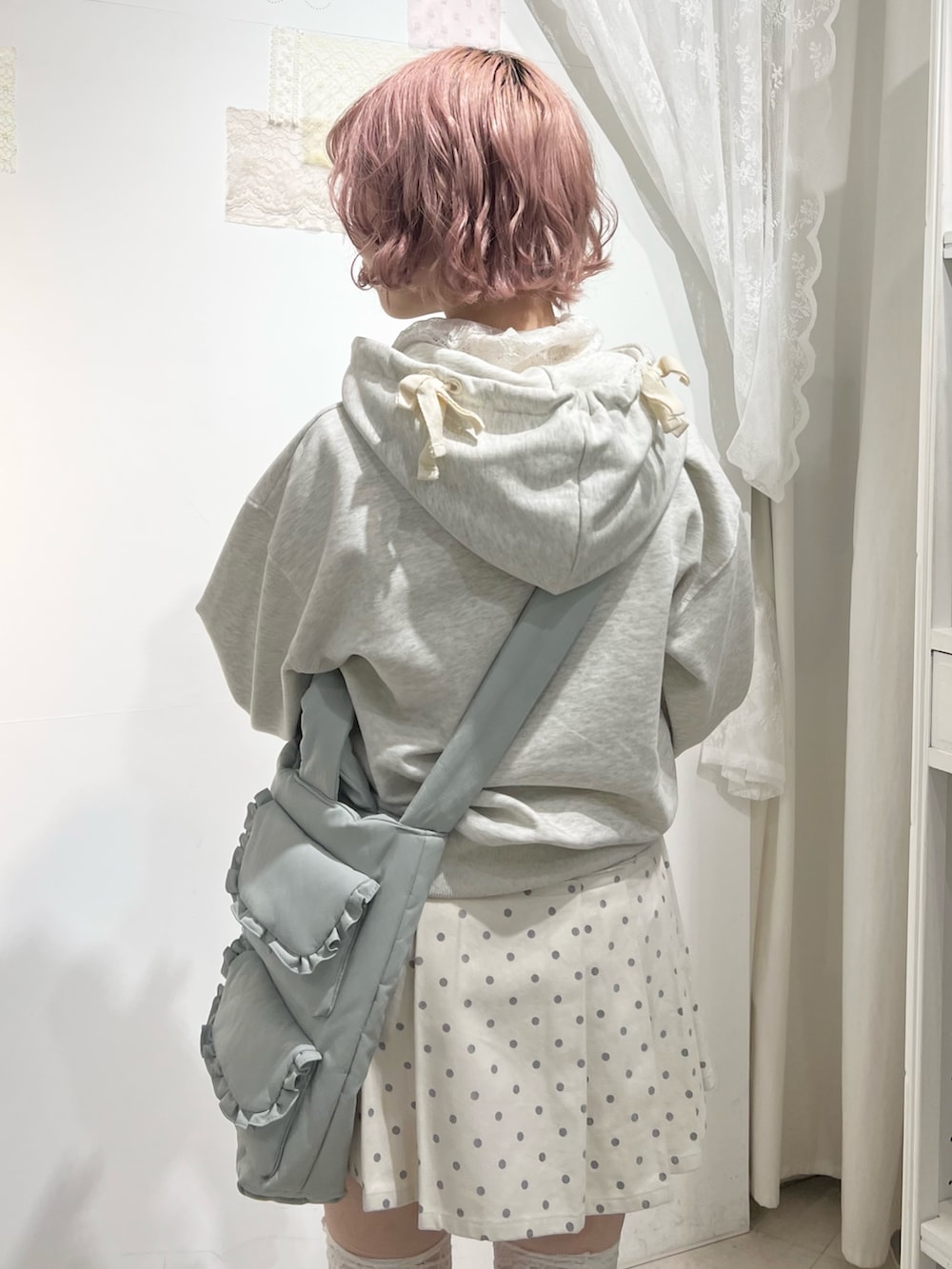 グレー系のパーカー、ホワイト系のスカート、ブルー系のショルダーバッグを着用したレディースの秋コーディネートの7枚目の写真