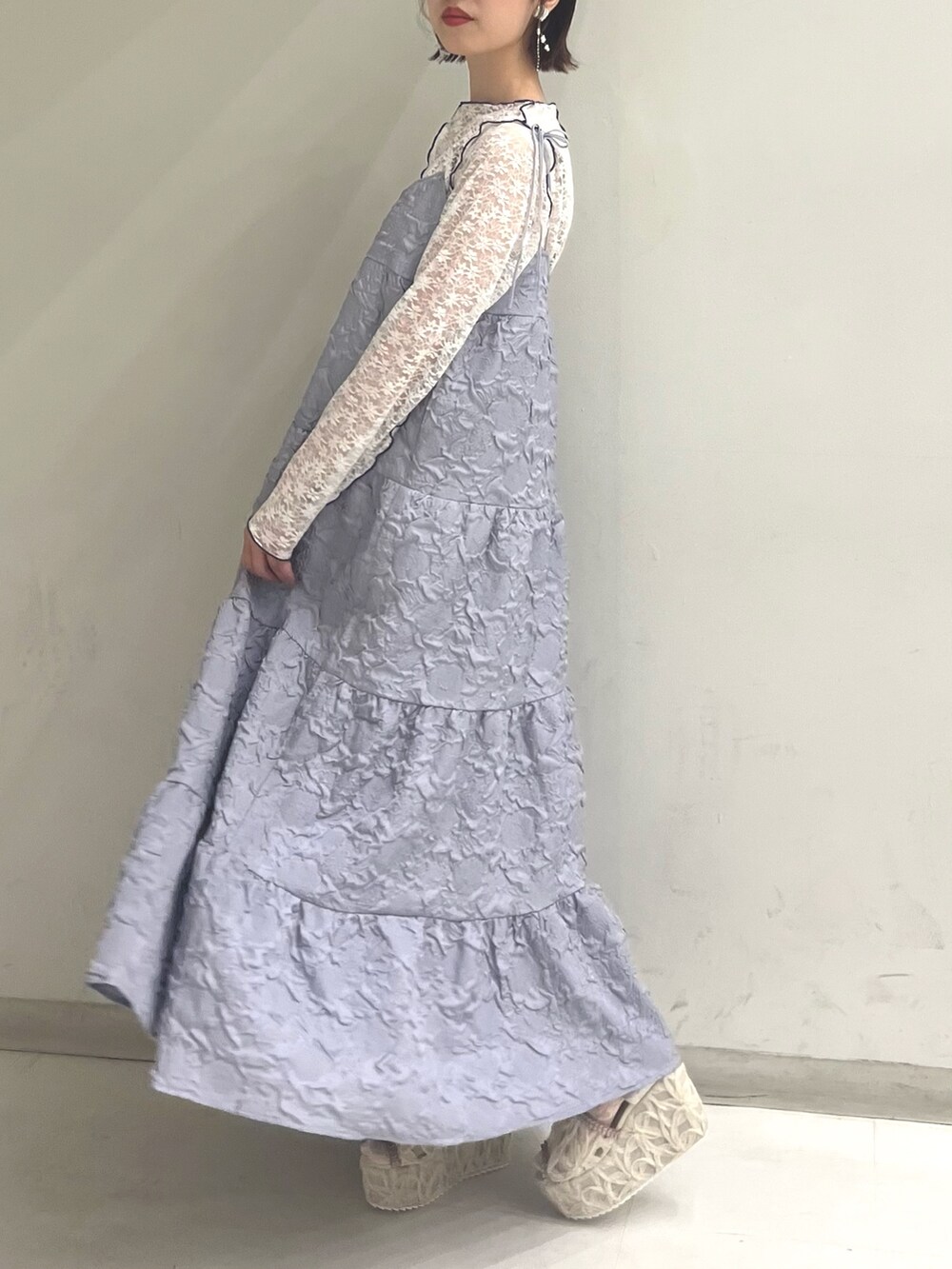 パープル系のワンピース、ホワイト系のTシャツ/カットソー、ホワイト系のサンダルを着用したレディースの夏コーディネートの5枚目の写真