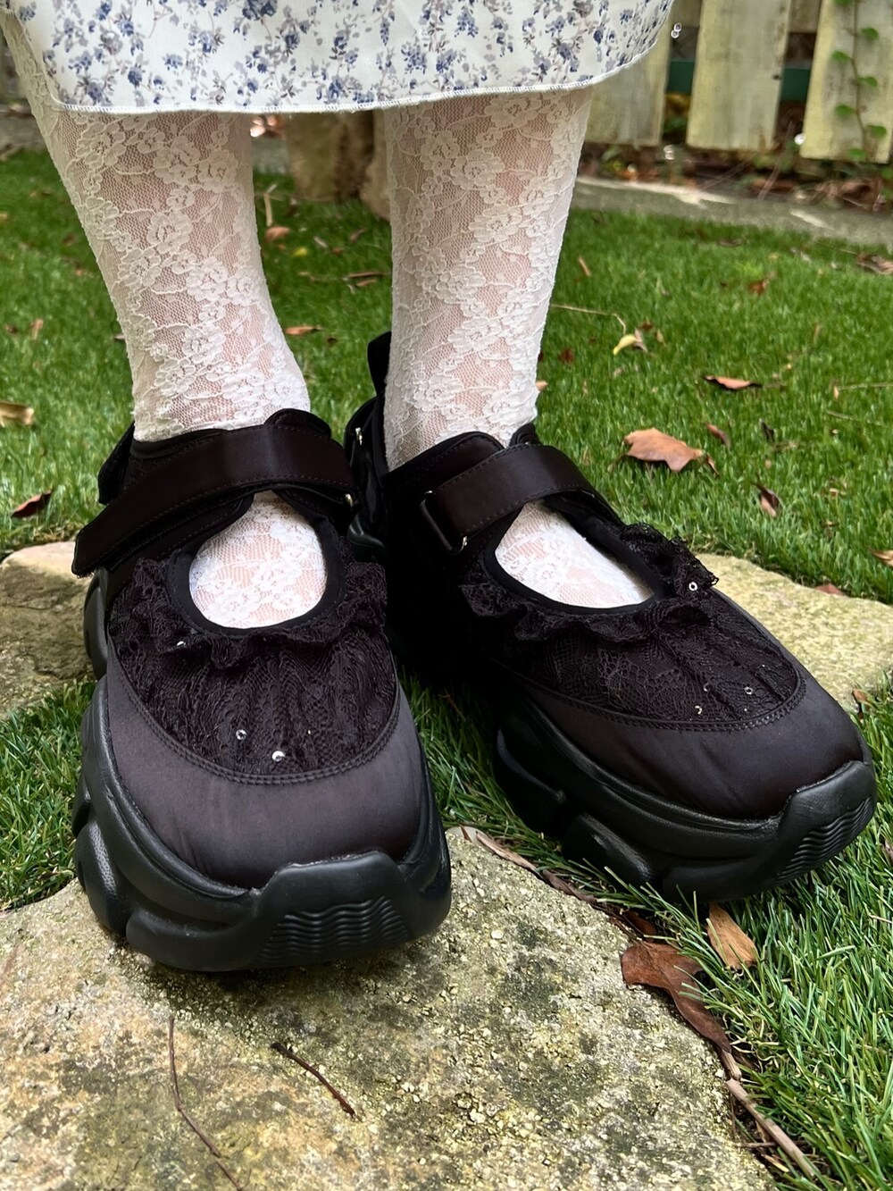 ホワイト系のワンピース、グレー系のニット/セーター、ブラック系のスニーカーを着用したレディースの秋コーディネートの9枚目の写真