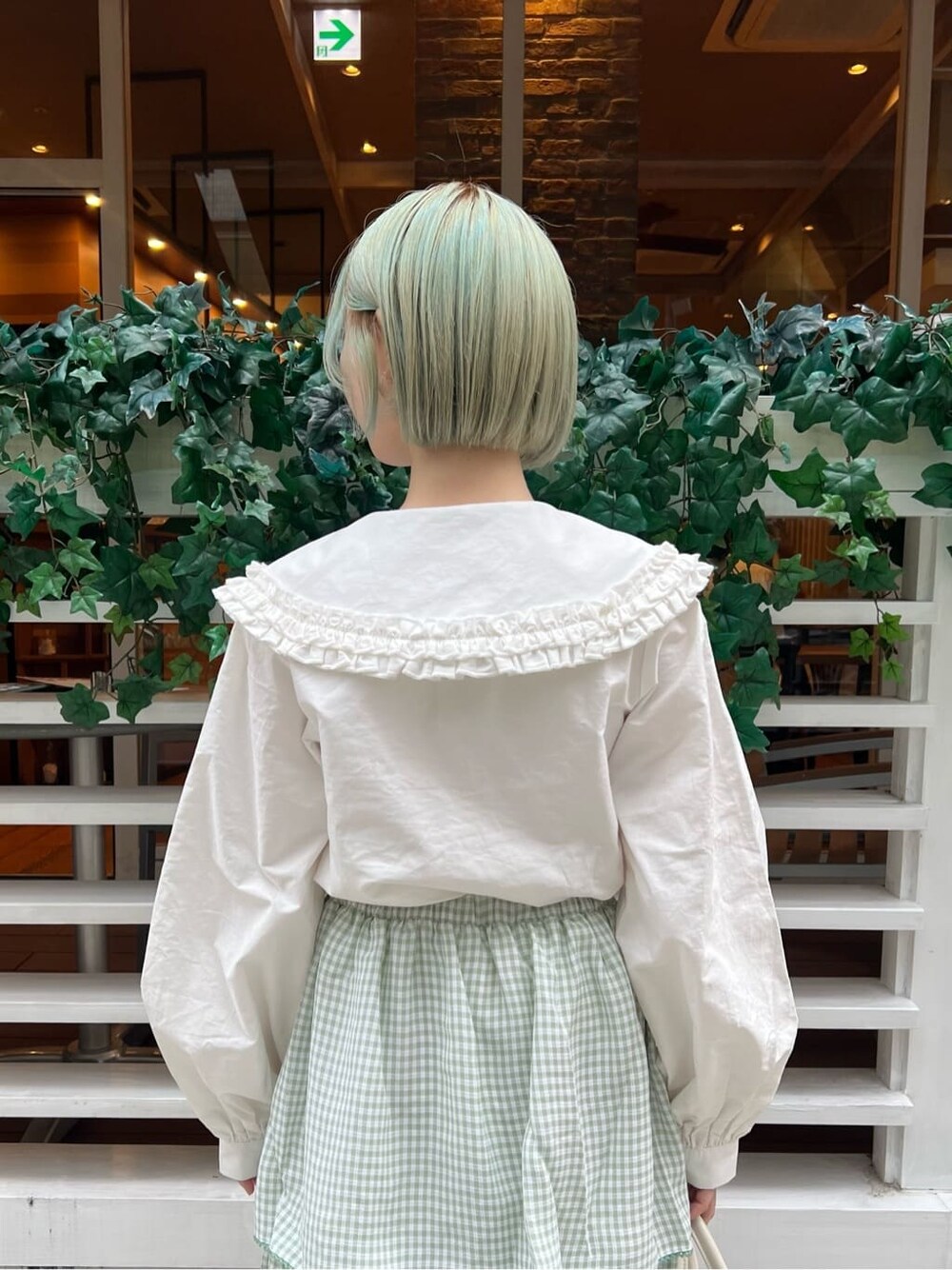 ホワイト系のシャツ/ブラウス、グリーン系のスカート、ホワイト系のボストンバッグを着用したレディースの秋コーディネートの6枚目の写真