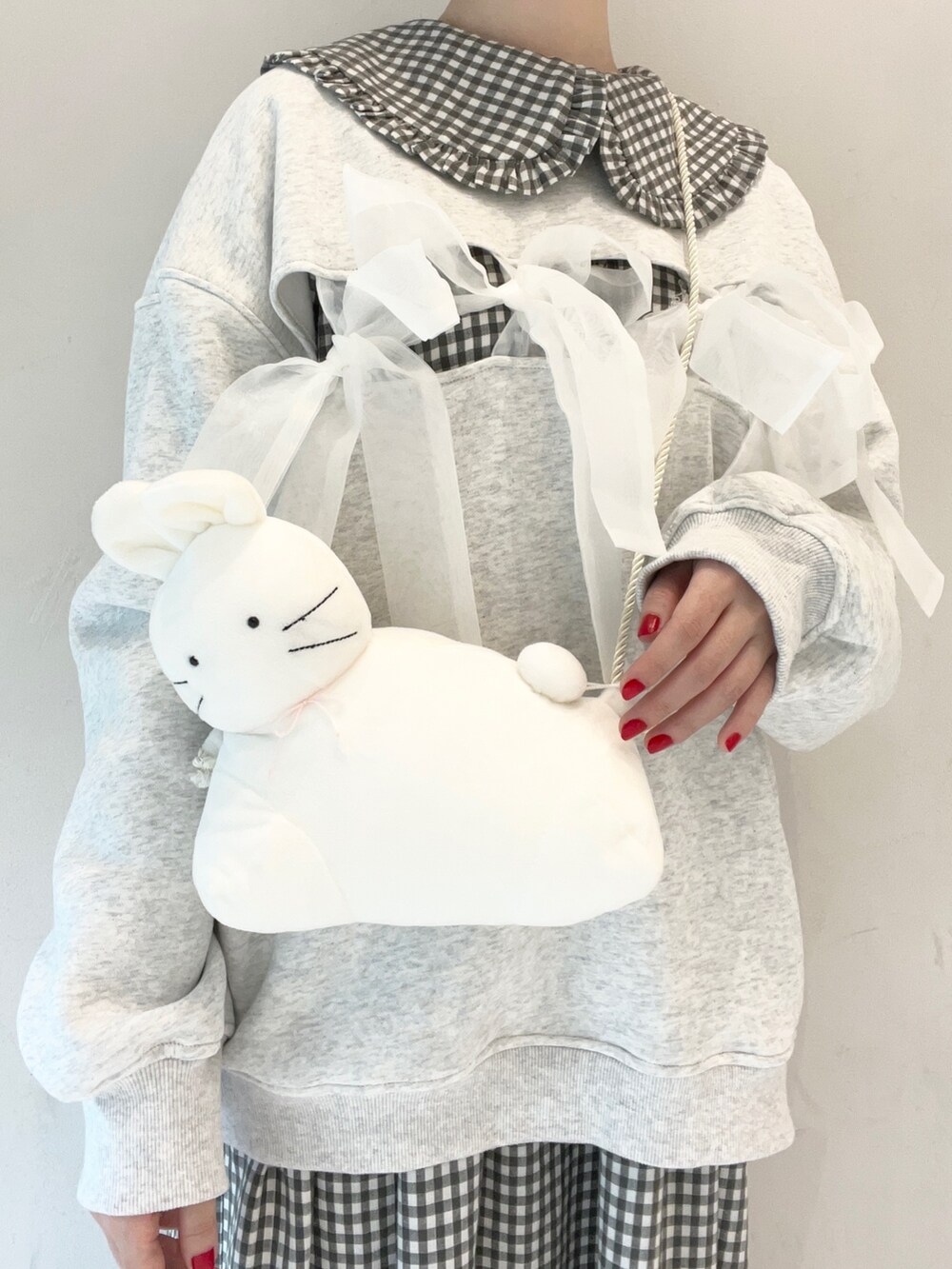 ブラック系のワンピース、ブラック系のスニーカー、ホワイト系のショルダーバッグを着用したレディースの冬コーディネートの8枚目の写真