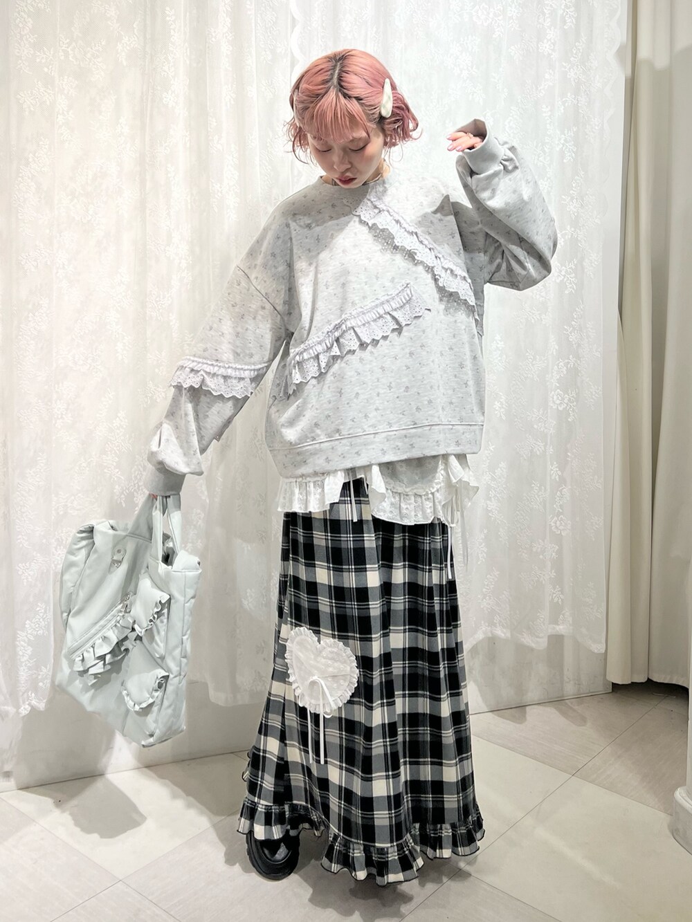 グレー系のスウェット、ベージュ系のスカート、ブラック系のスニーカーを着用したレディースの冬コーディネートの4枚目の写真