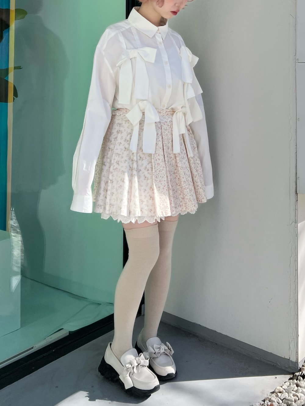 ホワイト系のシャツ/ブラウス、ピンク系のスカート、ホワイト系のスニーカーを着用したレディースの冬コーディネートの4枚目の写真