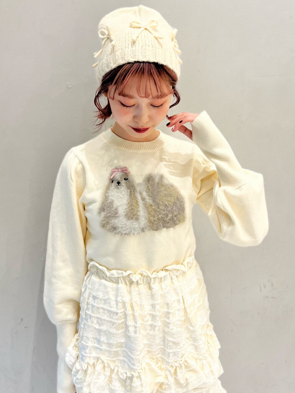 ホワイト系のノーカラーコート、ホワイト系のスカート、ホワイト系のニット/セーターを着用したレディースの冬コーディネートの10枚目の写真