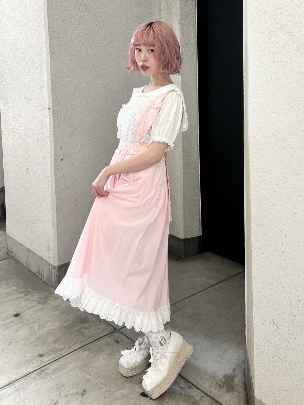 ホワイト系のTシャツ/カットソー、ピンク系のジャンパースカート、ホワイト系のサンダルを着用したレディースの夏コーディネートの3枚目の写真