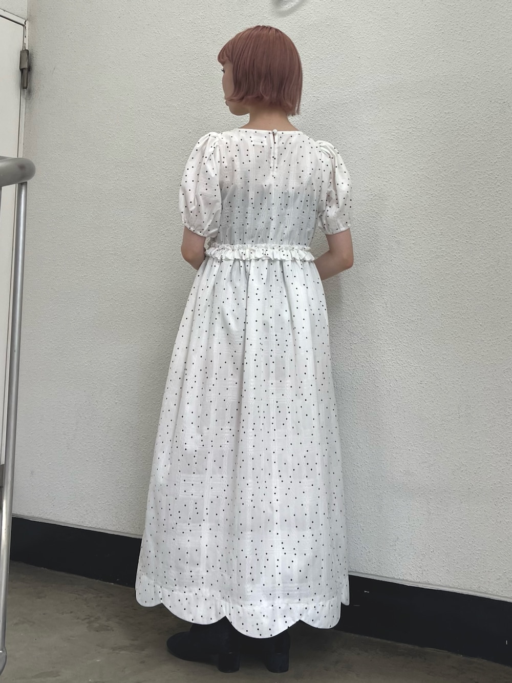 ホワイト系のワンピース、レッド系のハンドバッグ、ブラック系のパンプスを着用したレディースの春コーディネートの3枚目の写真