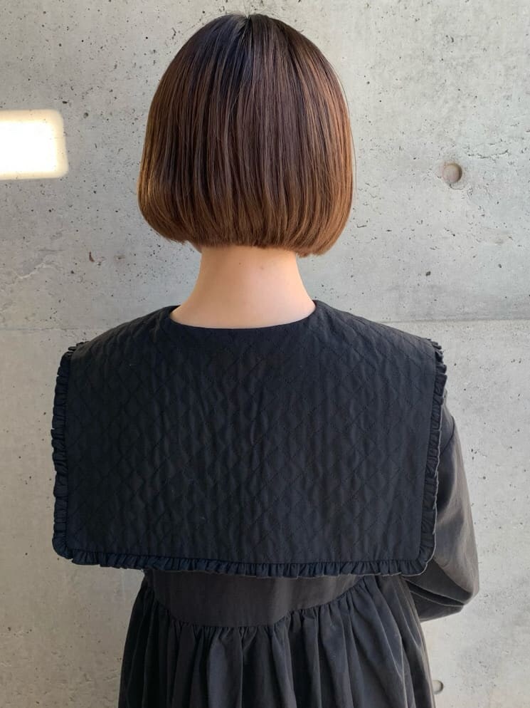ブラック系のパンプス、ブラック系のワンピース、ブラック系のショルダーバッグを着用したレディースの冬コーディネートの6枚目の写真