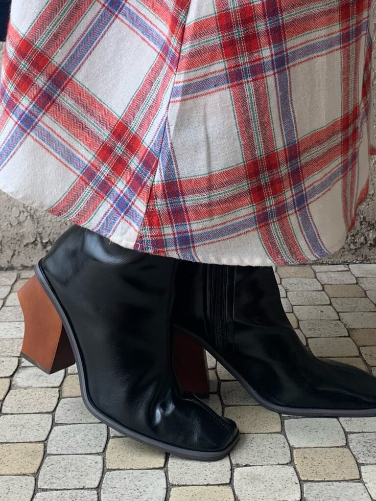 ブルー系のチェスターコート、ホワイト系のニット/セーター、レッド系のスカートを着用したレディースの秋コーディネートの7枚目の写真