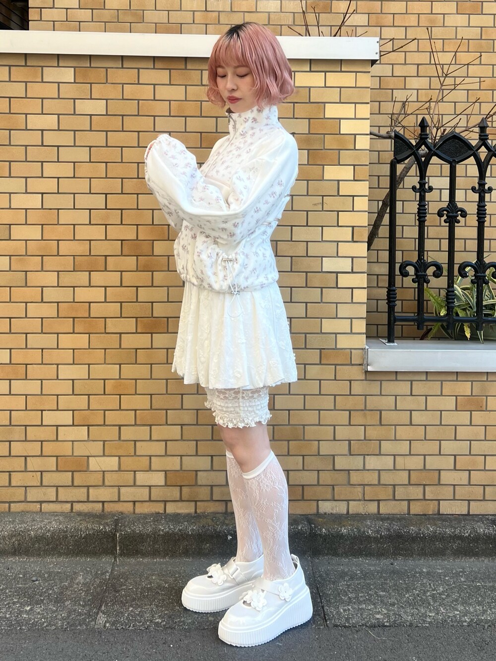 ピンク系のジャージ、ホワイト系のスカート、ホワイト系のスニーカーを着用したレディースの冬コーディネートの4枚目の写真