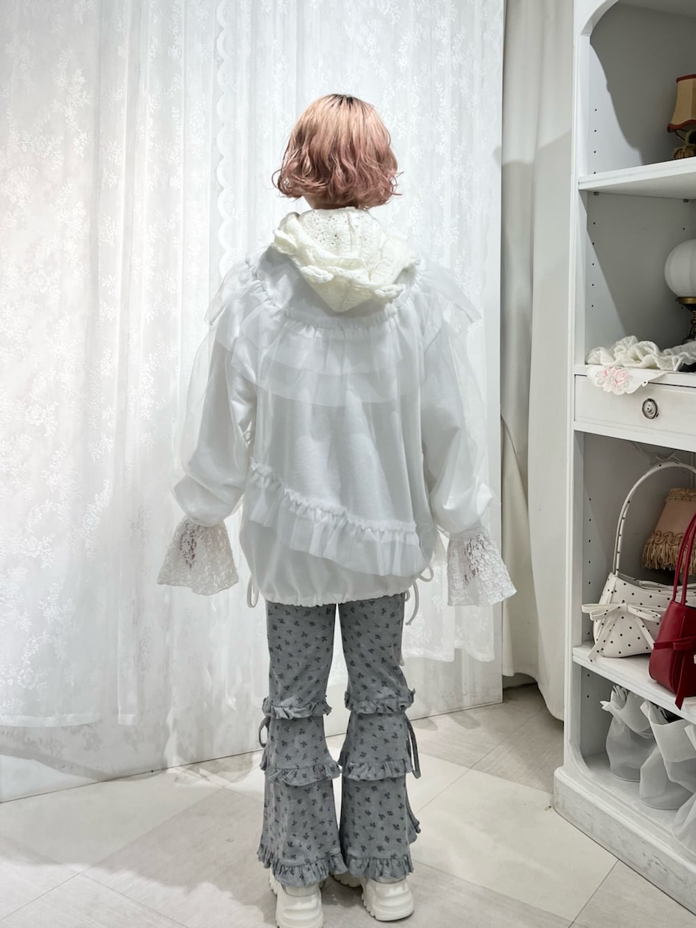 ホワイト系のスウェット、グレー系のスウェットパンツ、ブルー系のスニーカーを着用したレディースの夏コーディネートの4枚目の写真